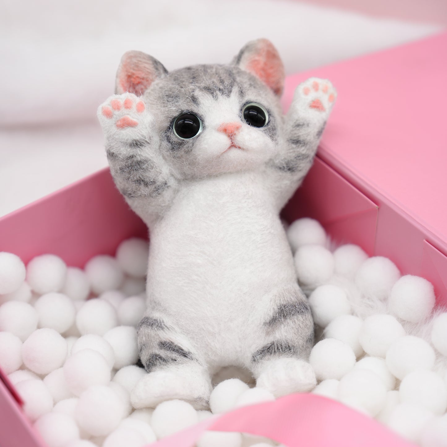 Adorable stuffed animal kitten with pink paw pads and fluffy fur