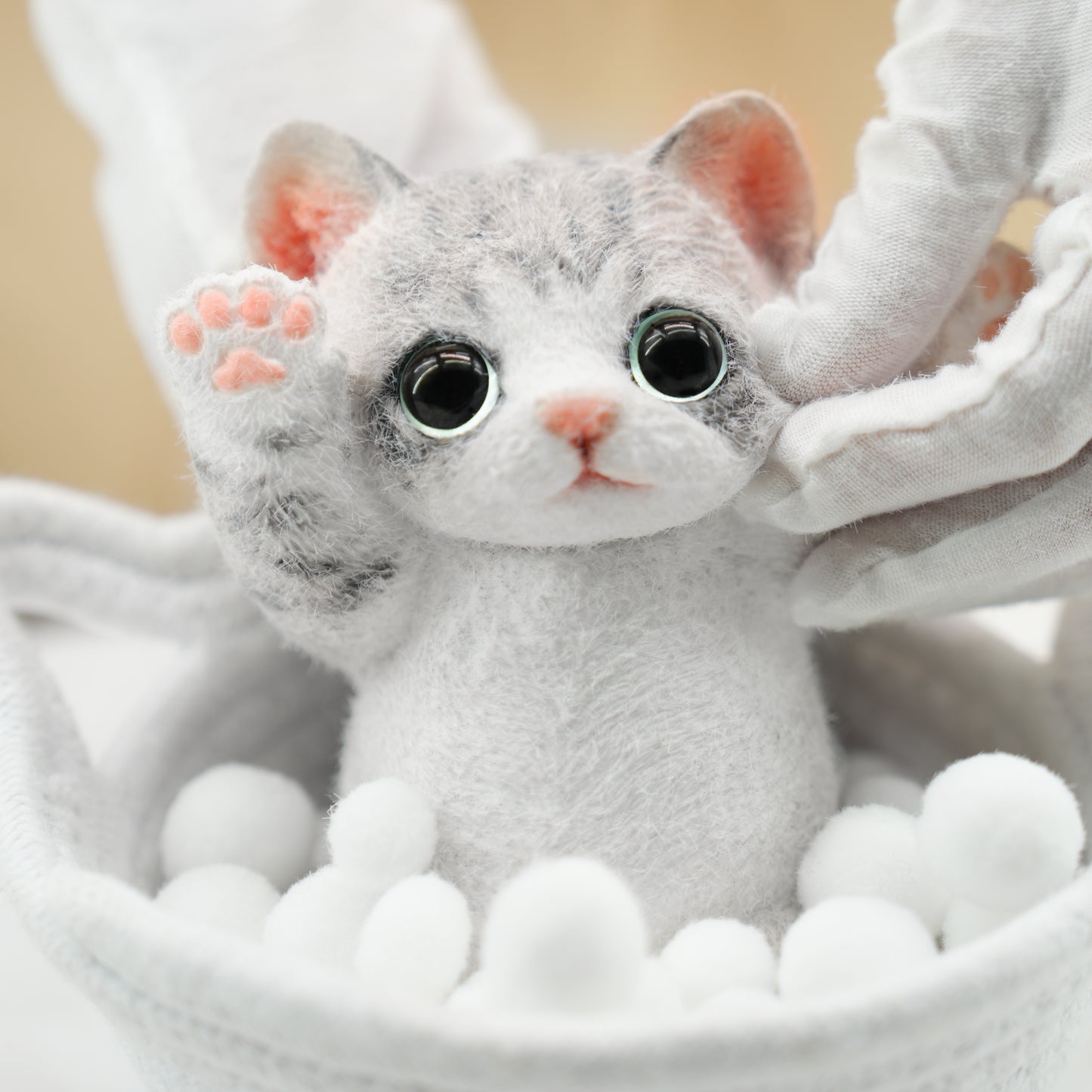 Soft plush kitten toy with large eyes and pink nose in a pink box